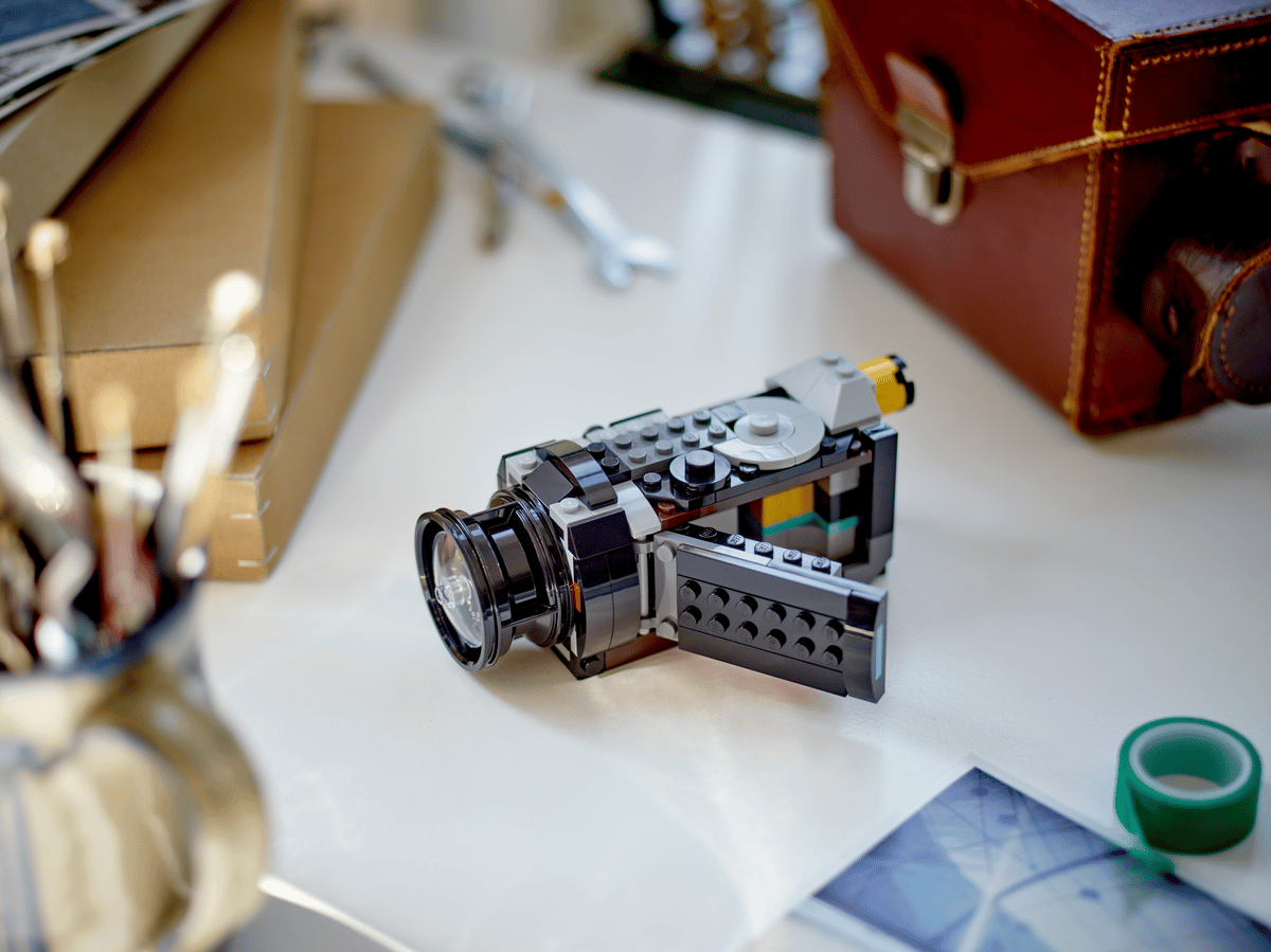 LEGO kamera byggesett på skrivebord med verktøy og koffert, perfekt gave for barn