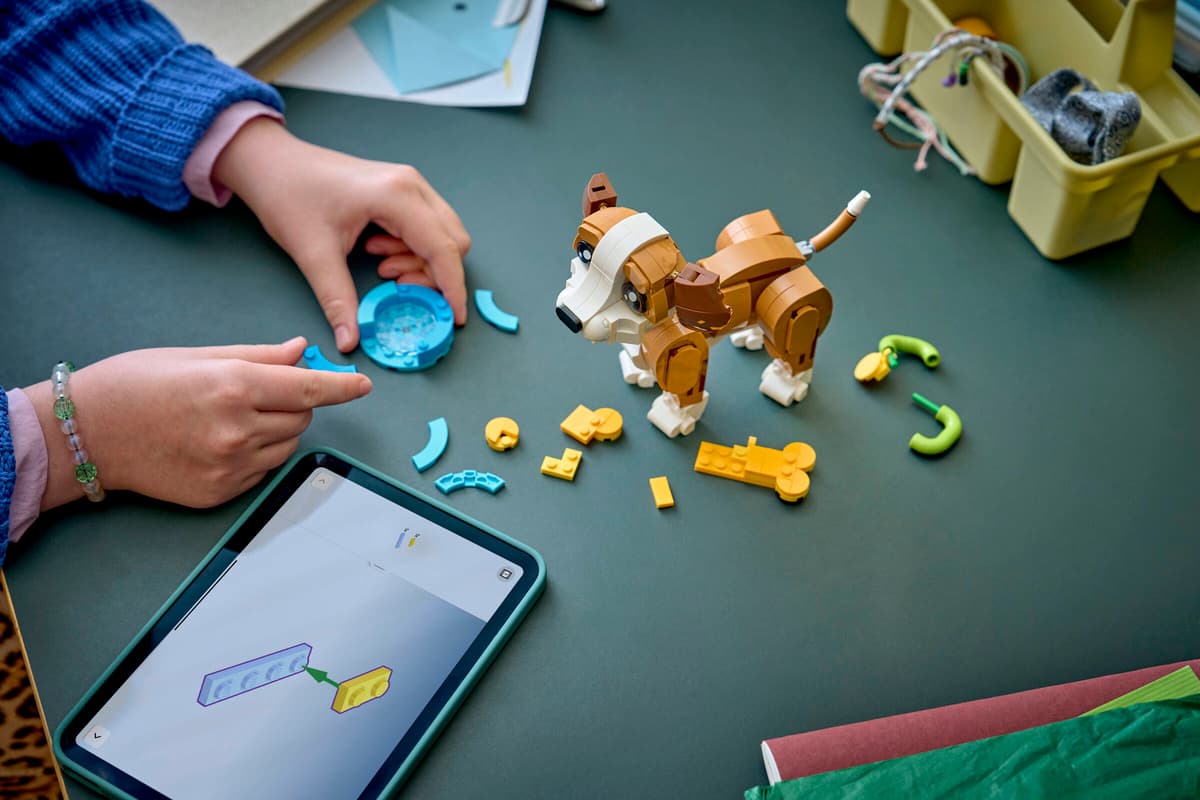 Barn bygger LEGO hund med tabletveiledning – leker og gaver for barn