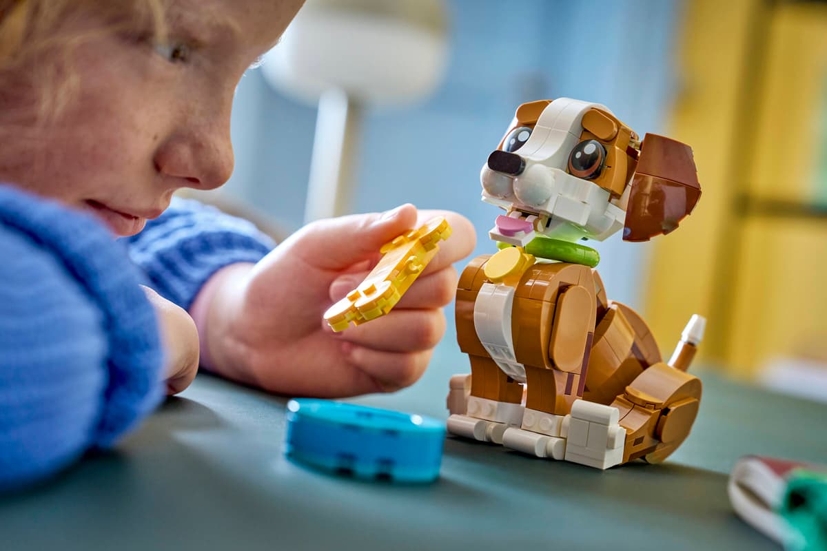 Barn bygger LEGO hund med gule og blå brikker, leker med populær barnelek