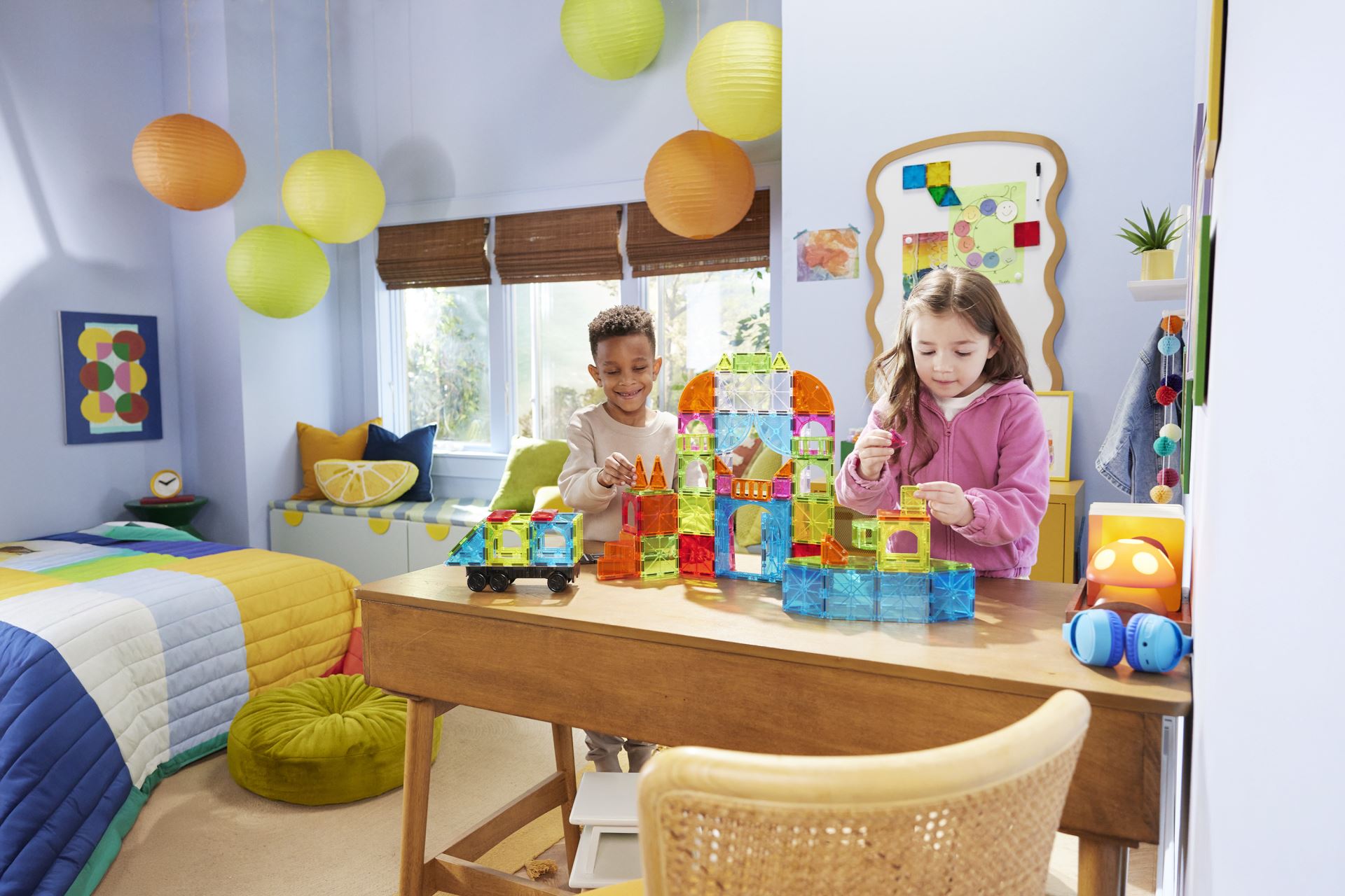 Barn leker med Magna-Tiles magnetiske byggeklosser i et fargerikt barnerom.