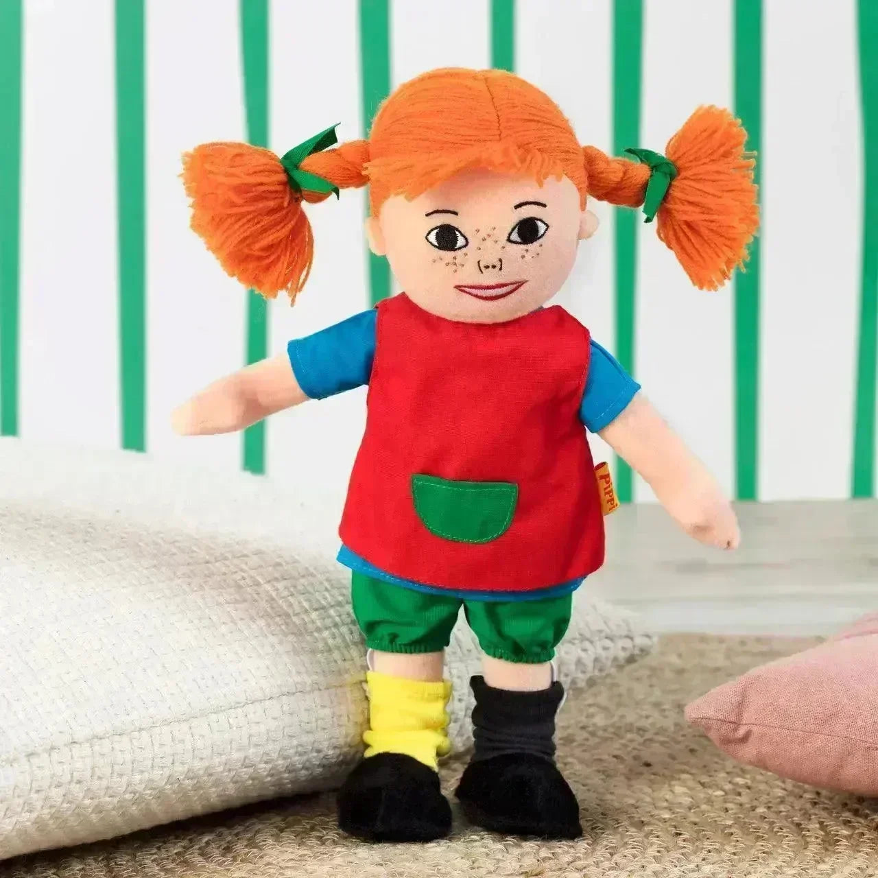 Pippi Langstrømpe dukke med rødt hår, røde klær og grønne bukser, barneleke på teppe