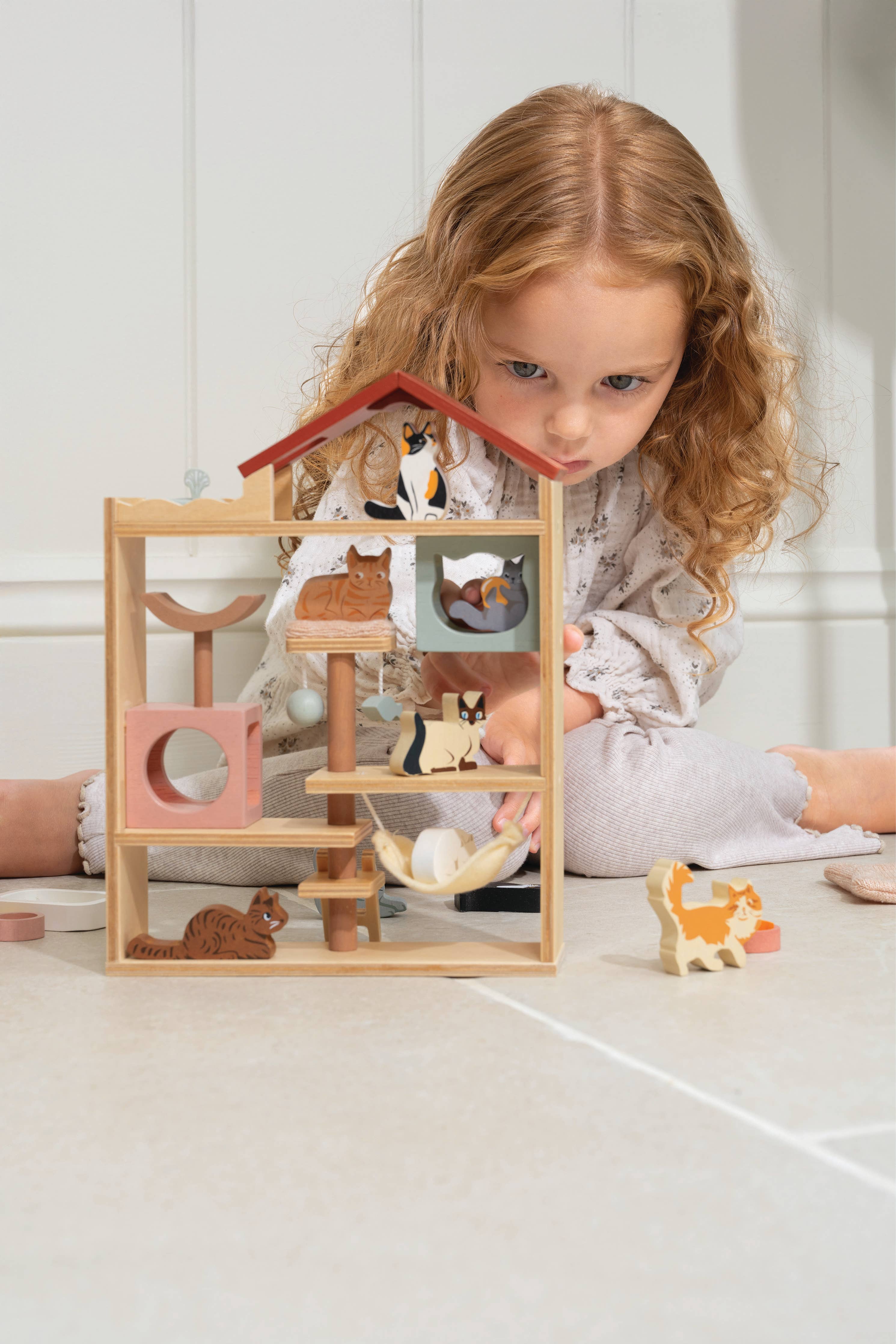 Barn leker med treleketøy hus og katter, perfekt barneleke for kreativ lek